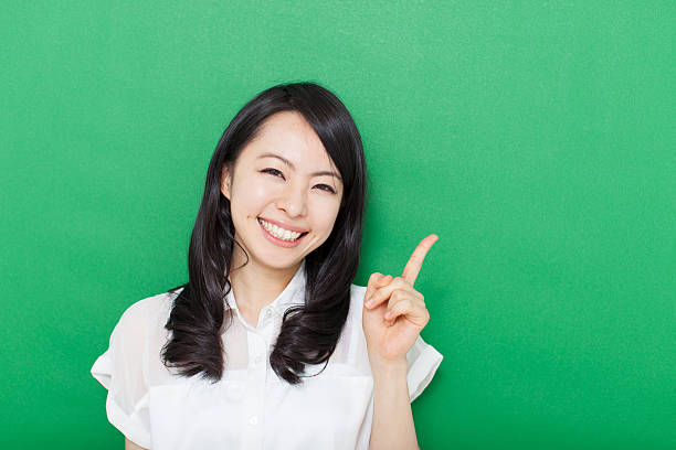 istock Japanese woman making gestures in green background 611180840