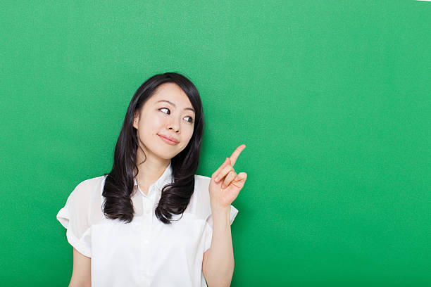 istock Japanese woman making gestures in green background 611180860