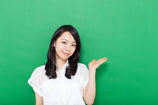 istock Japanese woman making gestures in green background 611180894