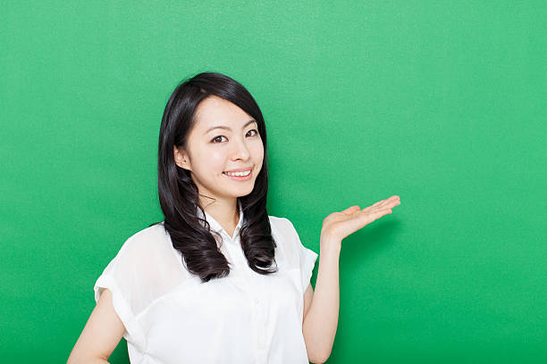 istock Japanese woman making gestures in green background 611180956