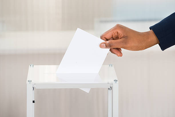 Person's Hand Putting Ballot In Box Close-up Of A Person's Hand Putting Ballot In Box ballot box photos stock pictures, royalty-free photos & images