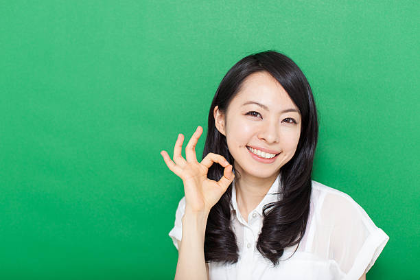 istock Japanese woman making gestures in green background 611181078