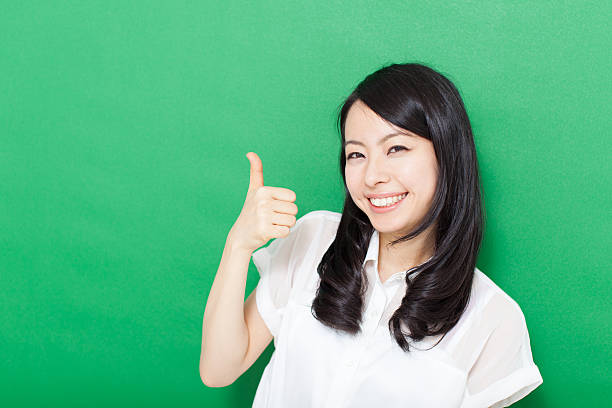 istock Japanese woman making gestures in green background 611181120