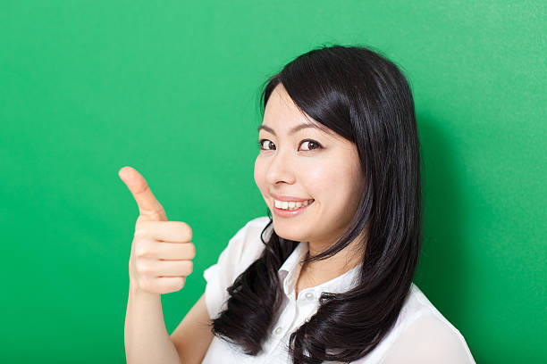 istock Japanese woman making gestures in green background 611181172