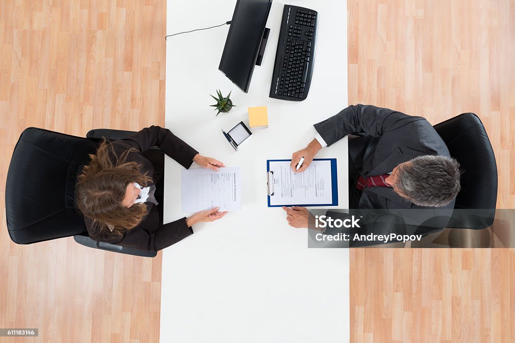 Businessman Interviewing Female Candidate High Angle View Of Mature Businessman Interviewing Female Candidate For Job Job Interview Stock Photo