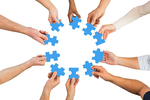 istock Creative Business People Holding Blue Jigsaw Pieces 611183842