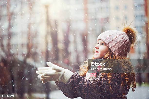 Kleines Mädchen Streckt Ihre Hand Um Fallende Schneeflocken Zu Fangen Stockfoto und mehr Bilder von Kind