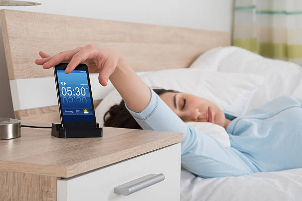 istock Woman Snoozing Alarm On Mobile Phone 611184784