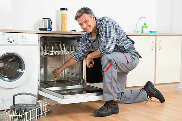 istock Repairman Repairing Dishwasher With Screwdriver In Kitchen 611185096