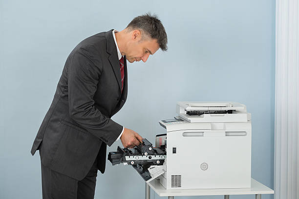 istock Businessman Fixing Cartridge In Printer Machine At Office 611186286