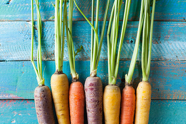 istock Organic Raw Carrots On Colorful Blue Wood Texture Table Background 611188498