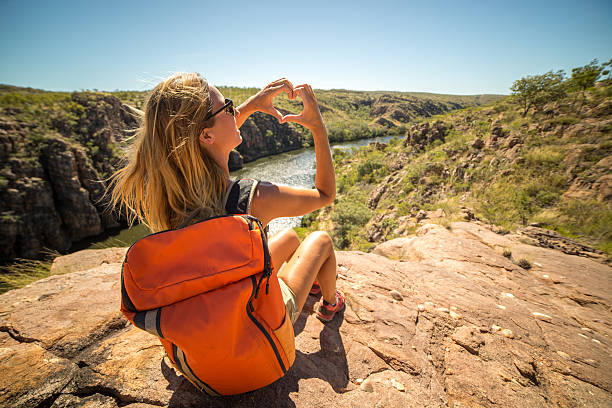 istock Hiker on mountain top makes heart shape finger frame 611188976