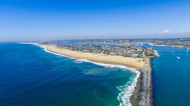 Wedge Newport Beach A view of the 'wedge' in Newport Beach, Southern California. The Wedge is a jetty that protects the Newport Harbor, as waves approach, the jetty funnels waves into double, even triple their size to create a unique and internationally popular surf destination. newport beach california stock pictures, royalty-free photos & images