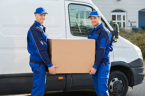 istock Delivery Men Carrying Cardboard Box Against Truck 611191120