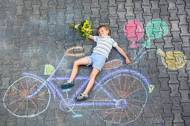 little kid boy having fun with bike chalks picture