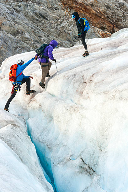 travail d’équipe sur le glacier glacé - crevasse photos et images de collection