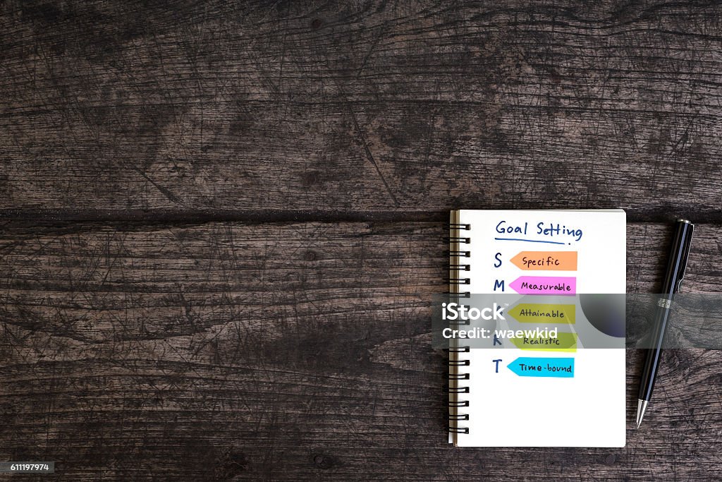 handwriting goal setting smart on open notebook handwriting goal setting smart on open notebook with pen  over grungy wooden desk, business concept Aspirations Stock Photo