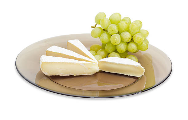 istock Slices of soft cheese and white grapes on glass dish 611199638