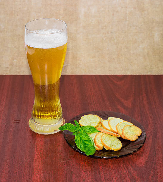 cerveza, rusks con albahaca en un platillo sobre superficie de madera - rusk county fotografías e imágenes de stock