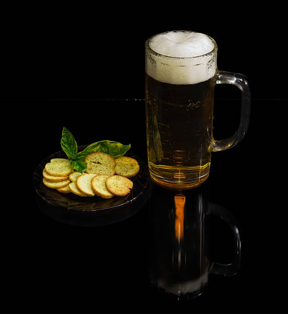 cerveza, rusks con albahaca sobre un platillo sobre fondo oscuro - rusk county fotografías e imágenes de stock