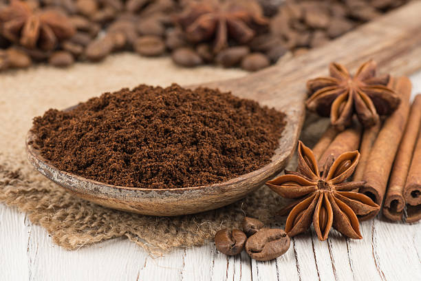 istock Ground coffee in a wooden spoon on  white wooden table. 611201868