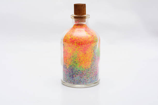 istock Decorative glass bottle with colorful sand isolated on white 611203896