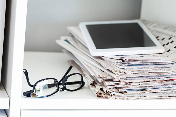 istock Stack of newspapers and tablet on wooden table 611204214