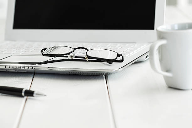 istock Eyeglasses on laptop and coffee 611204354