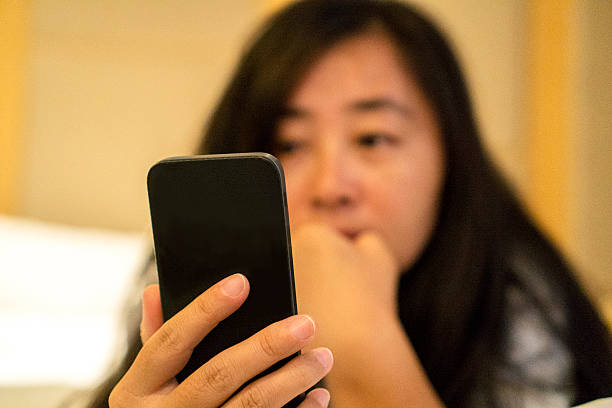 istock girl reading mobile phone on bed 611204544
