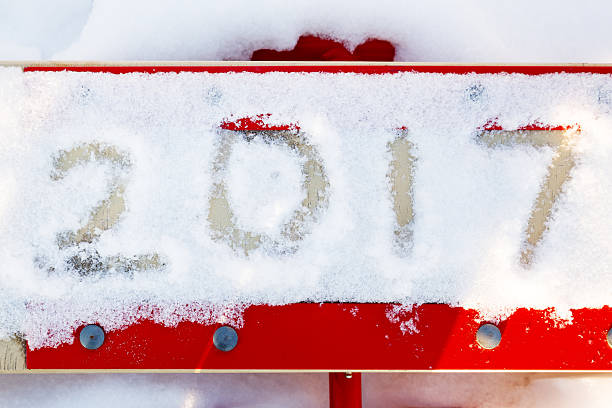 istock Numbers 2017 in the snow on the red swing for children. 611206432