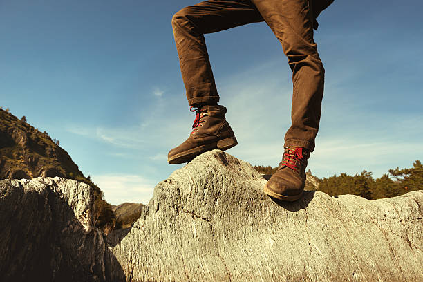 istock Men's legs closeup rock concept 611207738