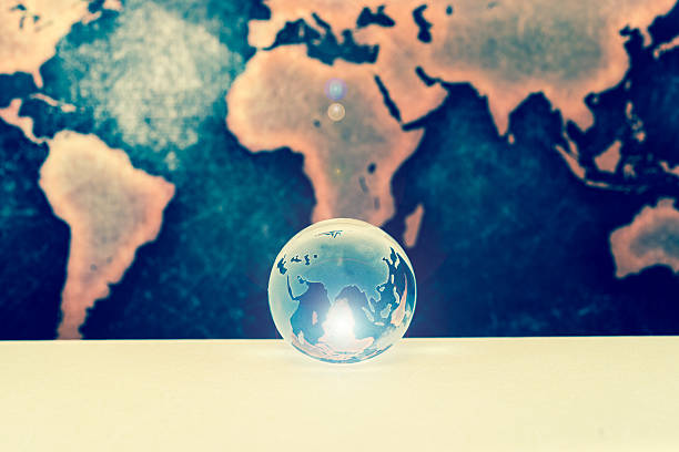 istock Crystal globe on books against grunge world map, lens flare 611211622