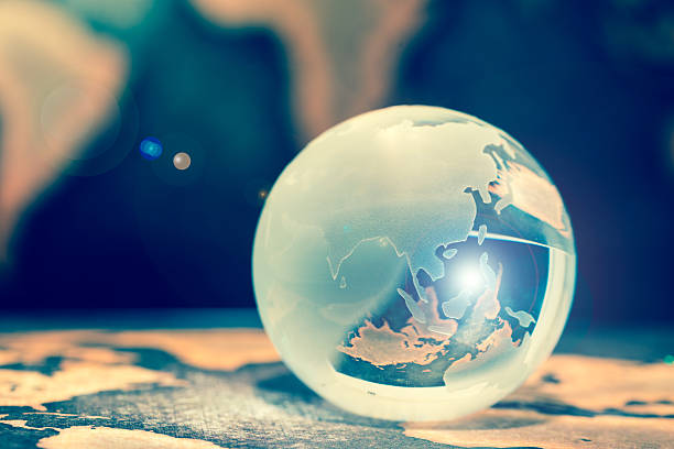 istock Crystal globe on books against grunge world map, lens flare 611211678