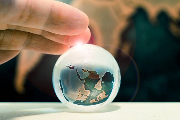 istock Crystal globe on books against grunge world map, lens flare 611211728
