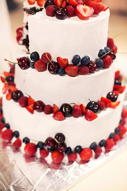 istock newlyweds cut wedding cake with berries 611212842