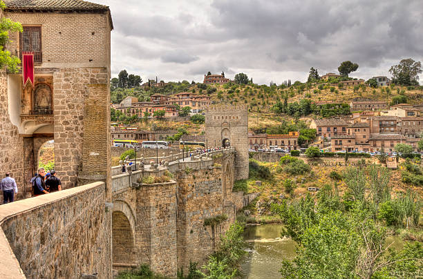 Toledo, Spain - May 28, 2016: Tourists walk on the historical Puente de San MartÃ­n, or Saint Martin's brdge, across the river Tagus in Toledo, Spain on May 28, 2016
