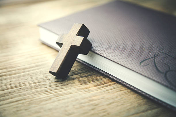 istock wooden crosses on book 611215342