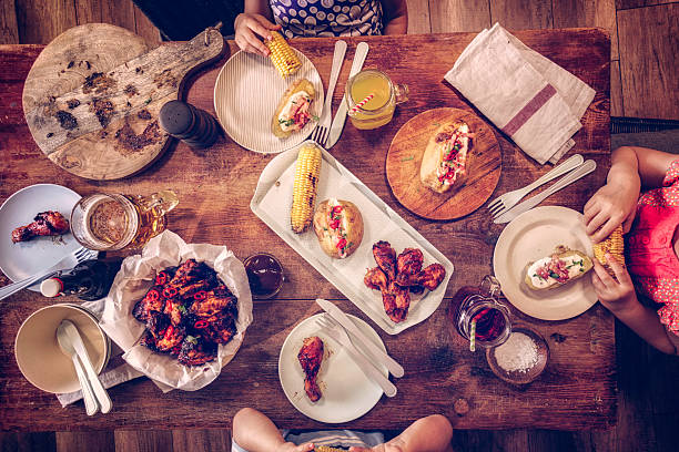 istock Eating Spicy Chicken Wings with Baked Potato and Corn 611216734