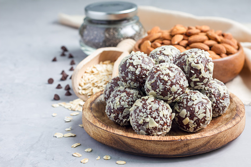 Healthy homemade paleo chocolate energy balls with rolled oats, nuts, dates and chia seeds, horizontal, copy space
