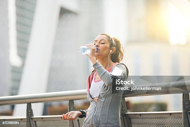 Woman Runner Is Having A Break And Drinking Water Stock Photo - Download Image Now - Drinking, Drinking Water, Women