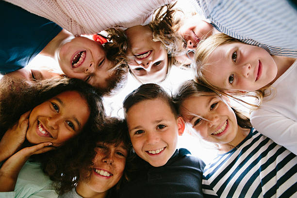 laughing group of kids in circle circle, group of people, children,  large group of people facing camera stock pictures, royalty-free photos & images