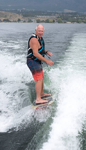istock Baby boomer wakesurfing, wakeboarding, vertical 611290486