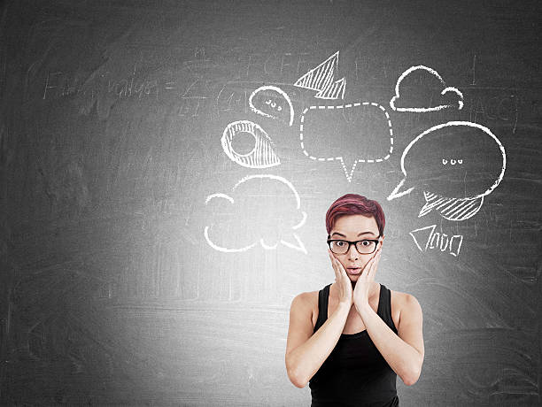 istock Girl near blackboard with speech bubbles 611292470