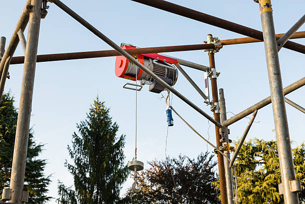 Industrial equipment: electric rope hoist Electric hoist in a construction site wire rope stock pictures, royalty-free photos & images