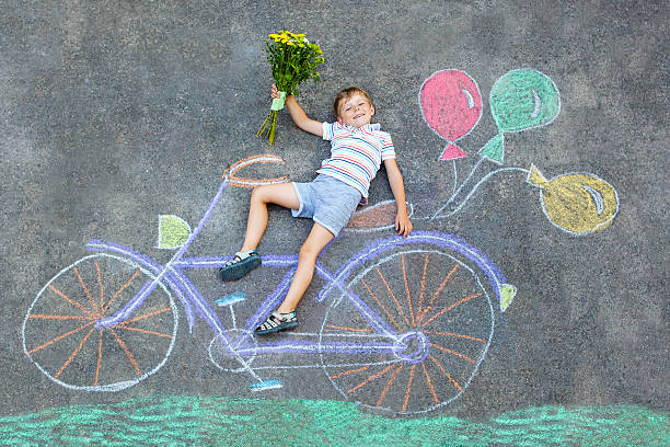 istock little kid boy having fun with bike chalks picture 611292546