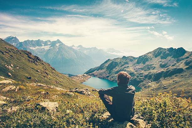 旅行者の男リラックス旅行ライフスタイルの山々と湖の風景 - mind trip ストックフォトと画像