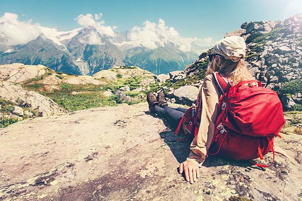 istock Woman Traveler with backpack relaxing on cliff with mountains landscape 611295814