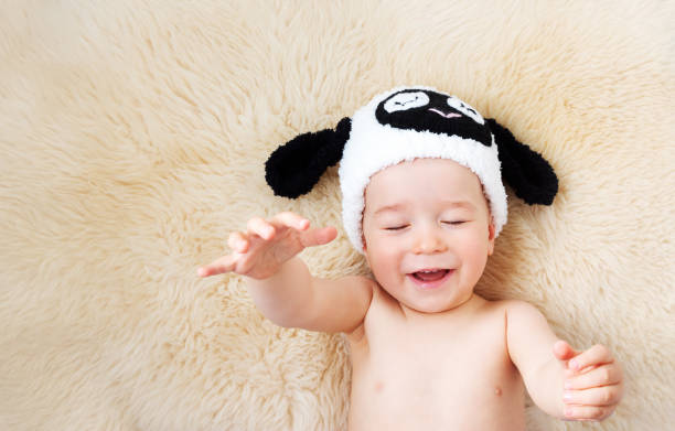istock one year old baby lying in sheep hat on lamb 611299212