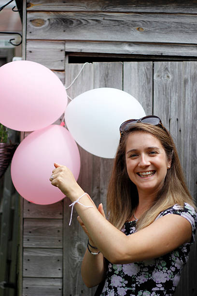 istock Women pointing to pink balloons 611300126
