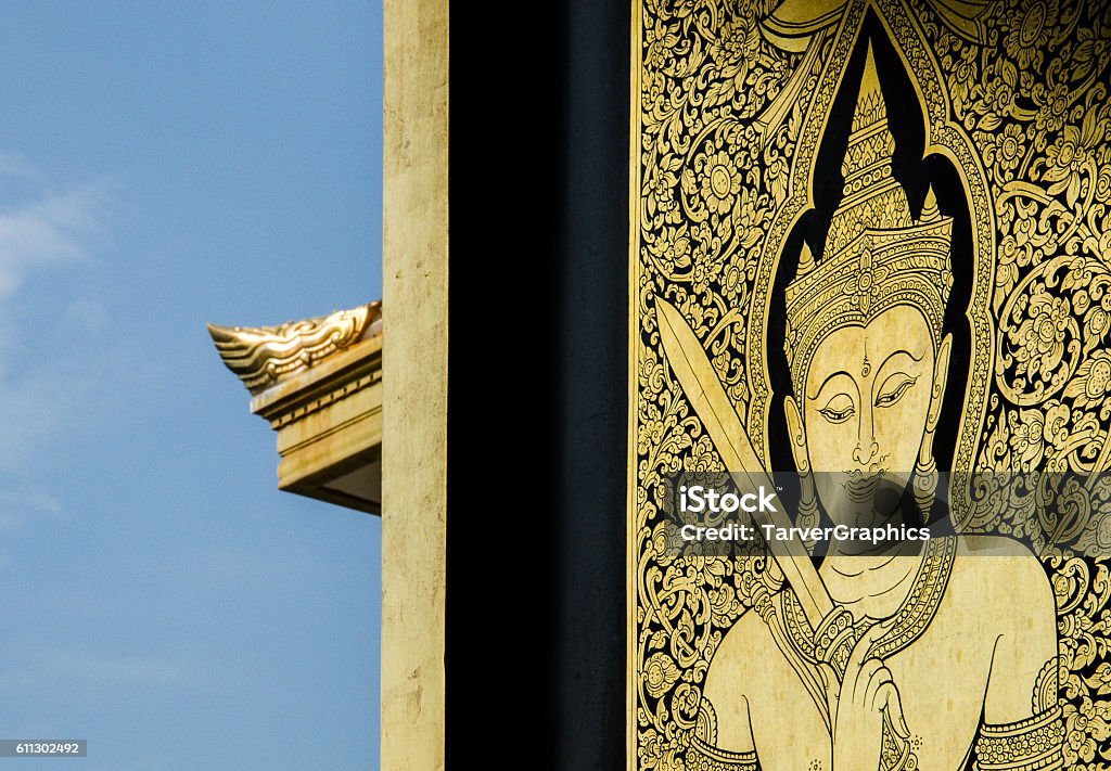 Wat Traimit Golden Engravement with Blue Sky Background Engraved historical artwork of buddha near the open window and blue skies Architecture Stock Photo